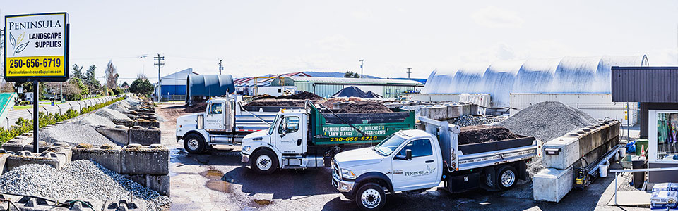 three trucks loaded with landscape material